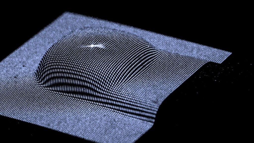 Laserprojektion auf ein technisches Objekt mit gewölbter Oberfläche zur präzisen Vermessung mittels Lichtschnittverfahren.
