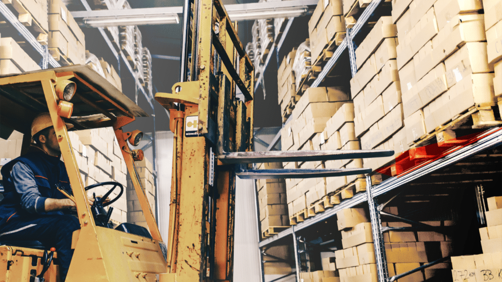 Gabelstapler im Hochregallager mit roter Laserlinie zur Markierung der Position der Gablzinken beim Einlagern von Paletten