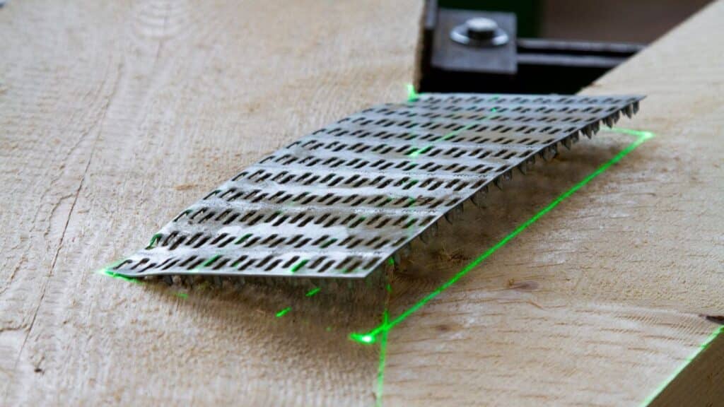 Laserprojektion markiert mit grünen Laserlinien die exakte Position der Nagelplatte auf dem Holz.
