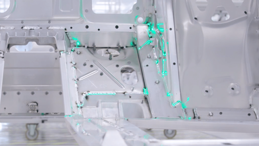 Laserprojektion zeigt Schweißnahtverläufe auf einer Fahrzeugkarosserie zur zerstörungsfreien Schweißnahtprüfung in der Automobilindustrie