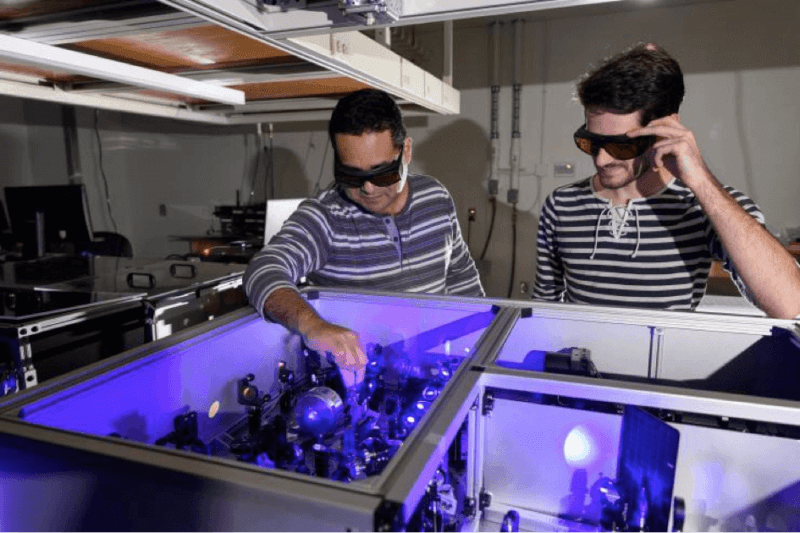 Carlos Silva (l.) in his lab at Georgia Tech with graduate research assistant Félix Thouin examining a setup to process laser light in the visible range for the testing of quantum properties in a halide organic-inorganic perovskite. Image: Georgia Tech/Rob Felt